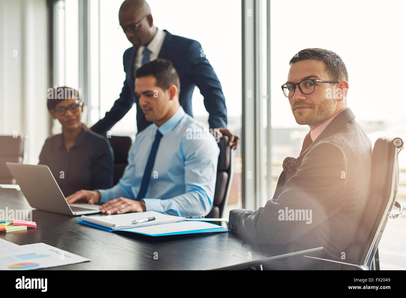 Junge multirassische Profigeschäft sitzen Teamarbeit an einem Tisch im Büro mit einem jungen Mann in den Vordergrund schalten Stockfoto