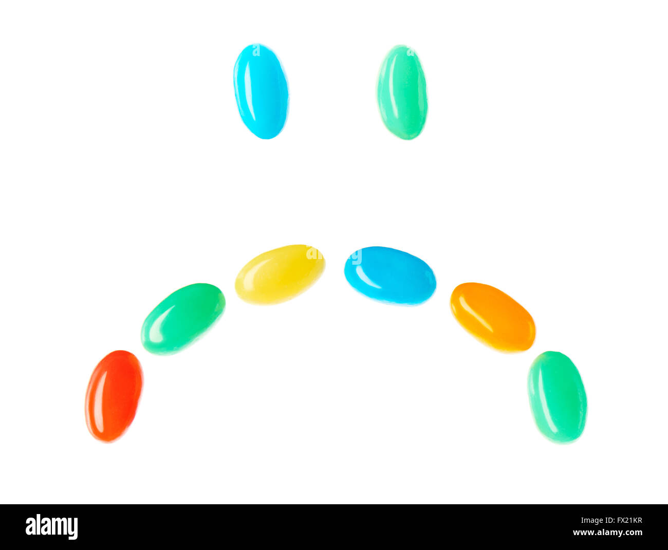 Traurig traurig Smiley gemacht von bunten Bonbons, die isoliert auf weißem Hintergrund Stockfoto