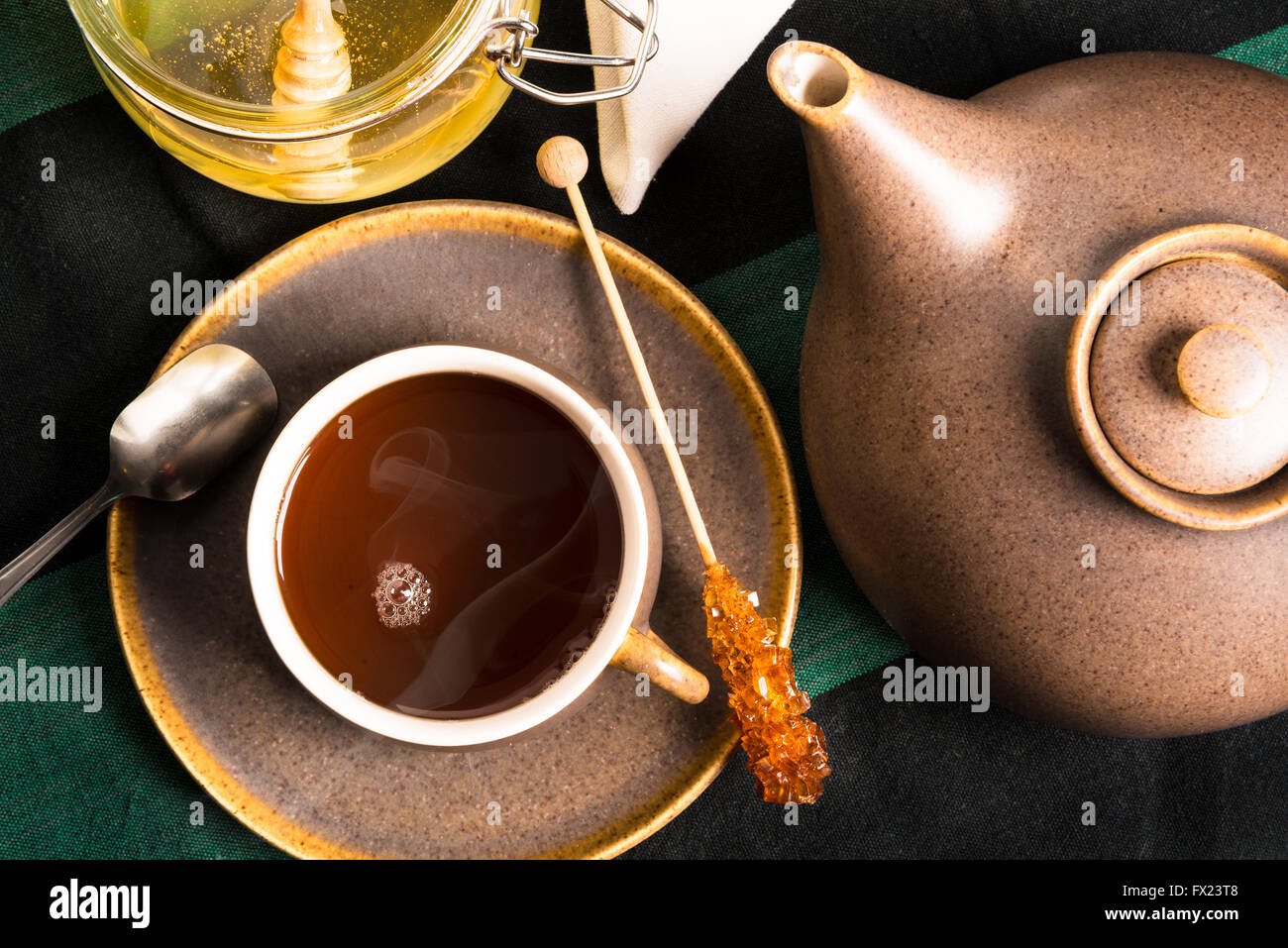 Eine Tasse heißen Tee auf einem Tisch mit Teekanne und Honig. Erschossen von oben Stockfoto
