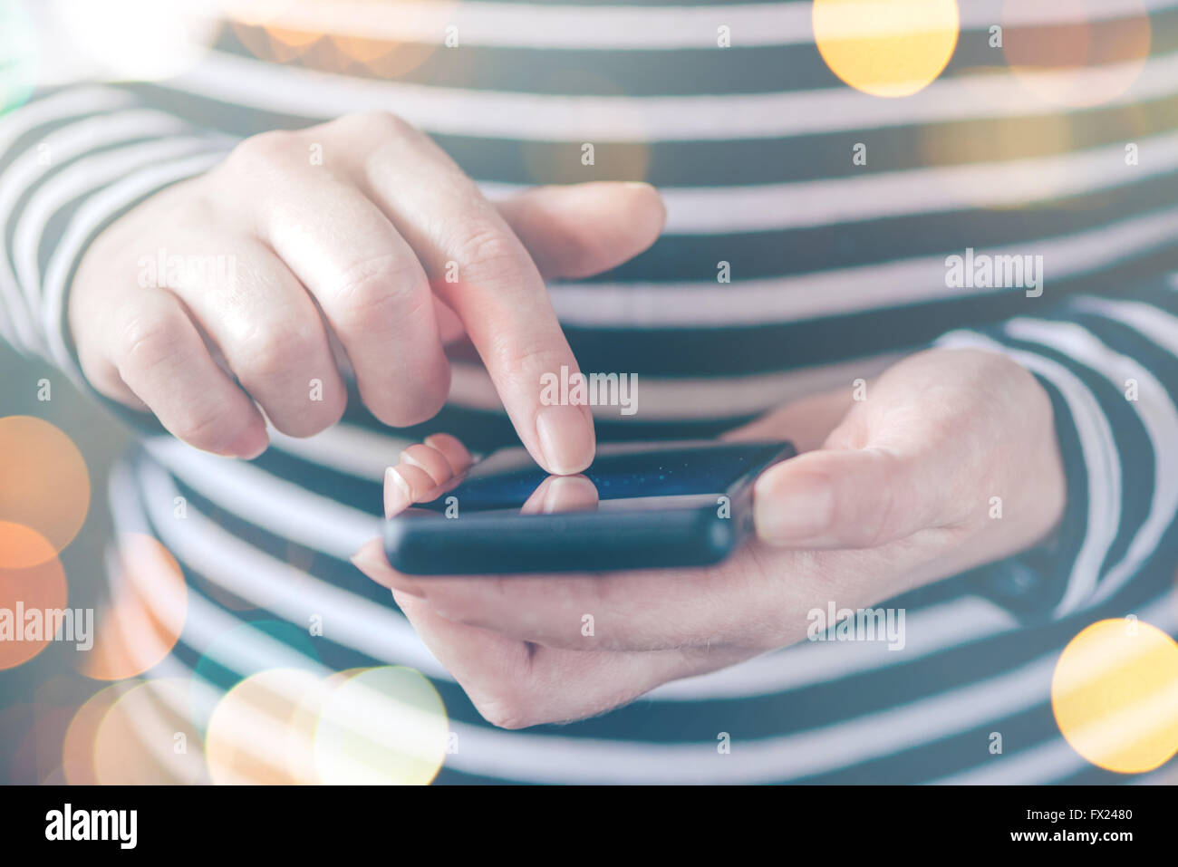 Frau SMS auf Smartphone, Sonne durch das Fenster, lässige