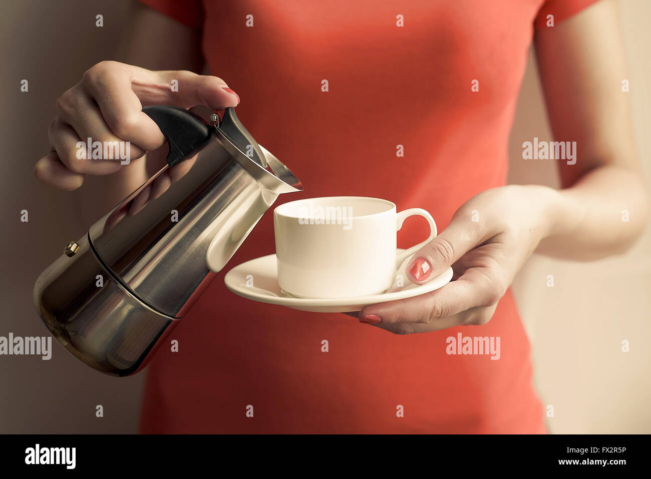 Weibliche Hand gießt Kaffee aus einer Kaffeemaschine ausgestattet. Konzentrieren Sie sich auf die Hand. Stockfoto