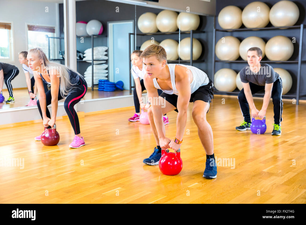 Konzentrierte sich die Gruppe Züge mit Kettlebells im Fitness-Studio Stockfoto