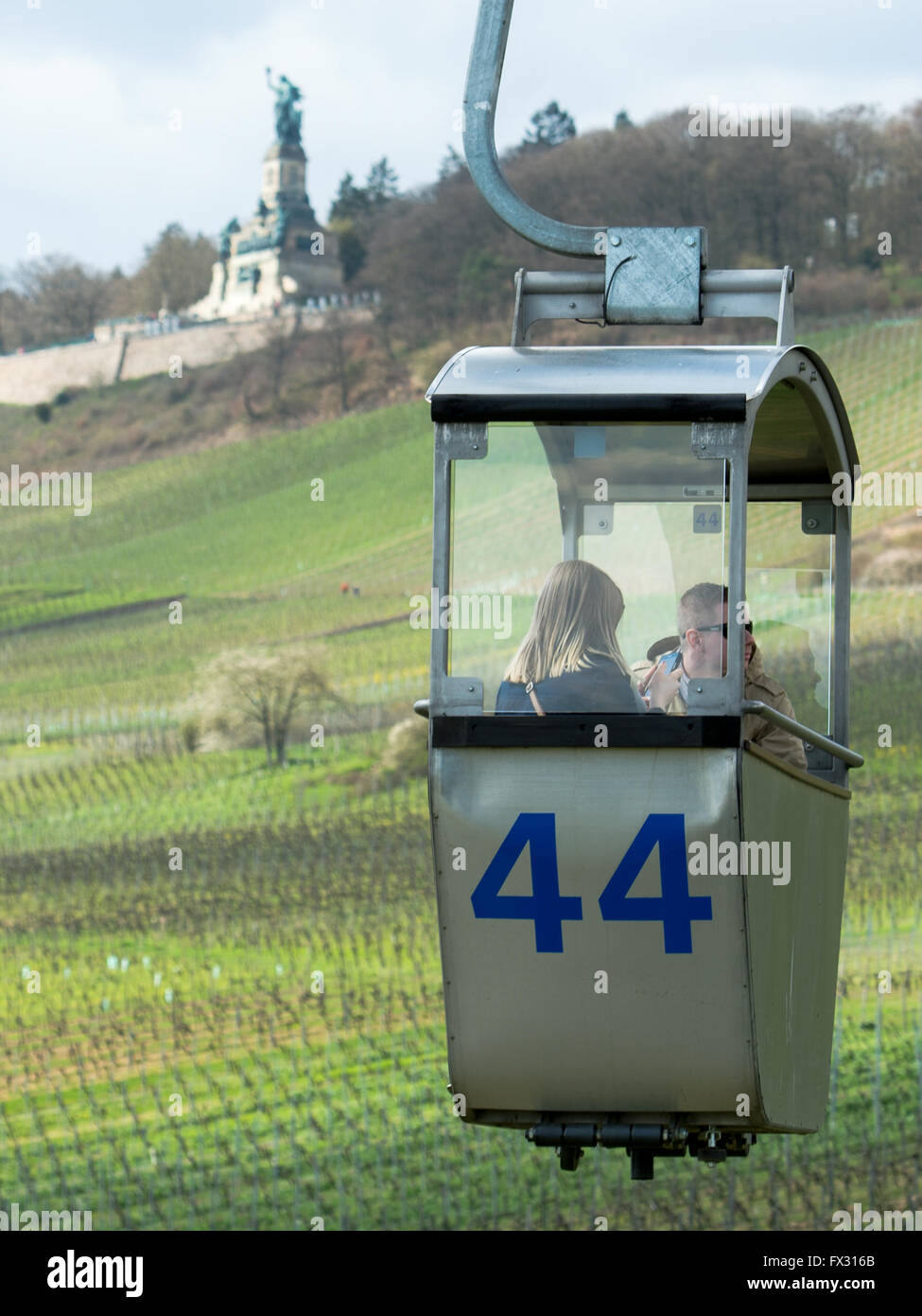 Rüdesheim, Deutschland. 8. April 2016. Zwei Besucher fahren die Seilbahn zum Niederwalddenkmal (Niederwald Denkmal) in Rüdesheim, Deutschland, 8. April 2016. Das Denkmal, das kennzeichnet eine Statue der Germania wurde 1883 eingeweiht und gilt als eines der berühmtesten Wahrzeichen der deutschen Mittelrhein-Region. Foto: ALEXANDER HEINL/Dpa/Alamy Live News Stockfoto