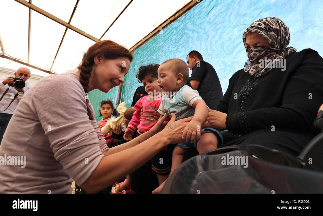 (160411)--MAFRAQ, 11. April 2016 (Xinhua)--US-Schauspielerin und UN Population Fund (UNFPA) Goodwill Ambassador Ashley Judd (L) hält ein Baby während ihres Besuchs in Al Zaatari Flüchtlingslager in Mafraq, Jordanien, 10. April 2016. (Xinhua/Mohammad Abu Ghosh) Stockfoto