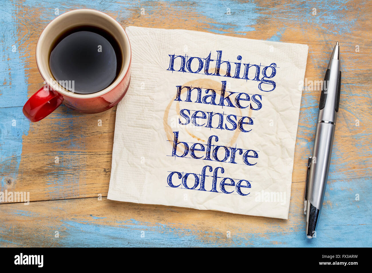 Nichts ist sinnvoll vor Kaffee - Handschrift auf einer Serviette mit Tasse Kaffee vor Grunge Holz Hintergrund Stockfoto
