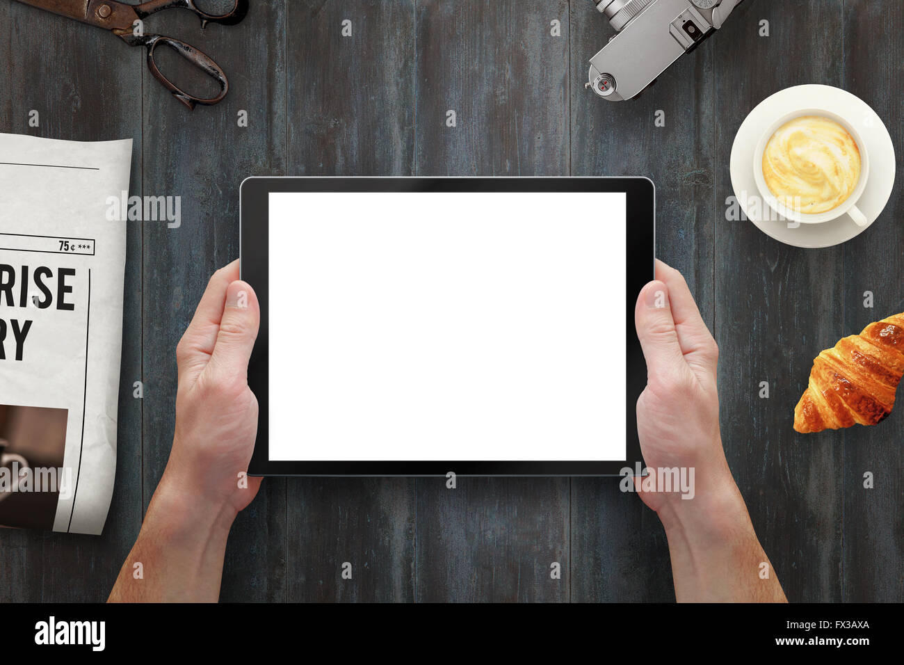 Tablet mit isolierten Bildschirm im Menschen die Hände. Morgen mal mit Zeitung, Croissant, Kaffee am Tisch. Stockfoto