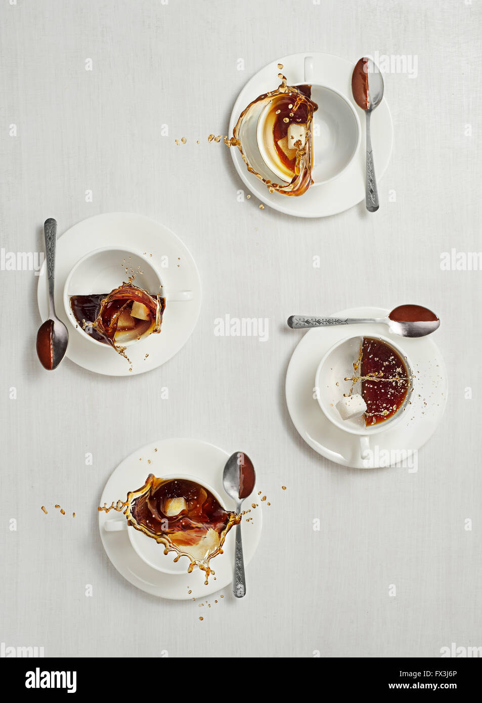 Kaffeetassen mit Spritzern auf weißem Hintergrund Stockfoto