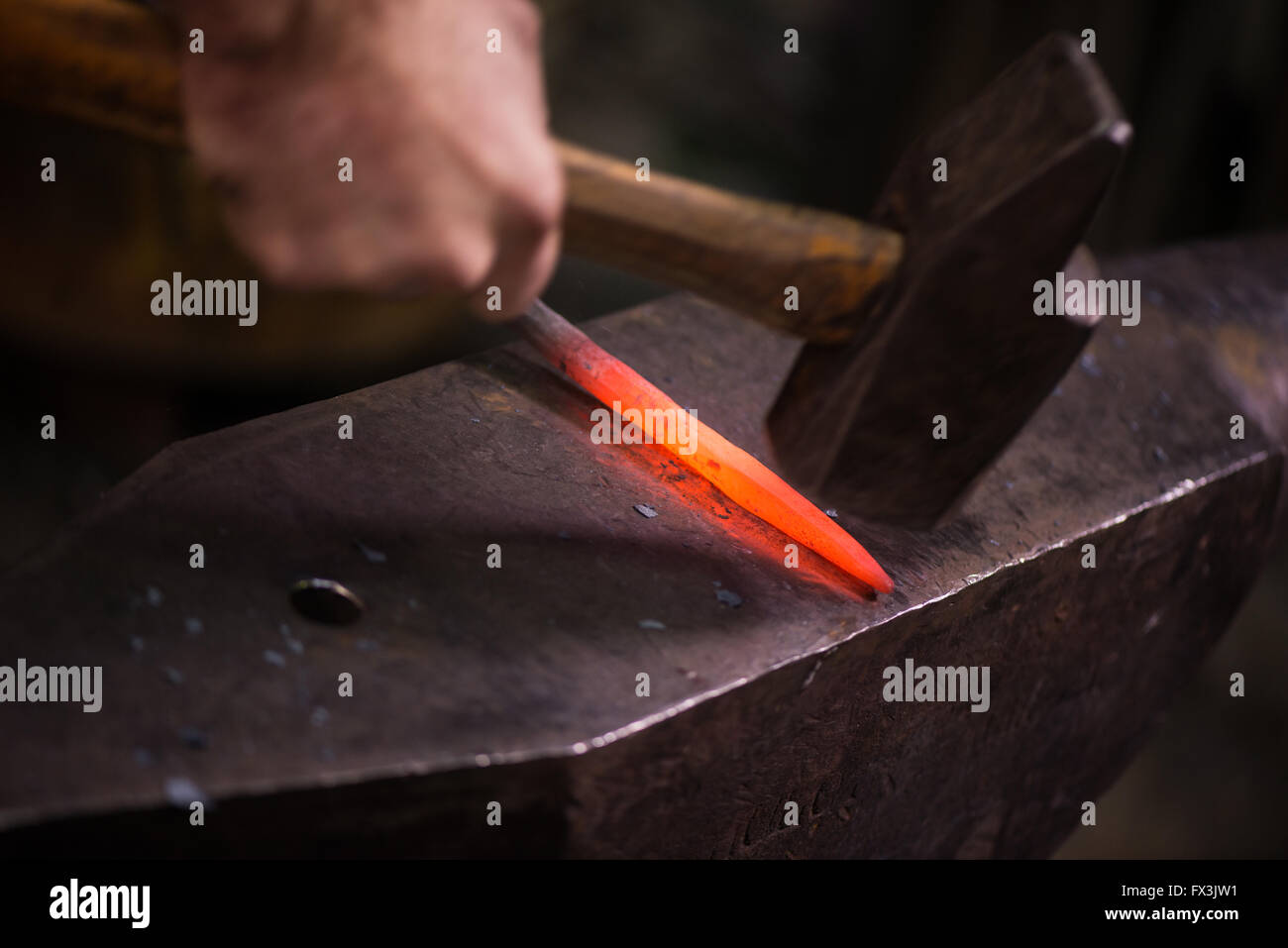 Stahlarbeiters heißen Eisen im Workshop schmieden Stockfoto