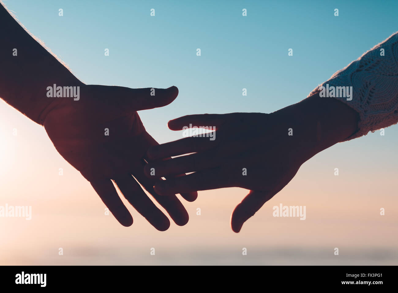 Paar Hände gelangen Silhouette auf Himmel und Meer Hintergrund. Stockfoto