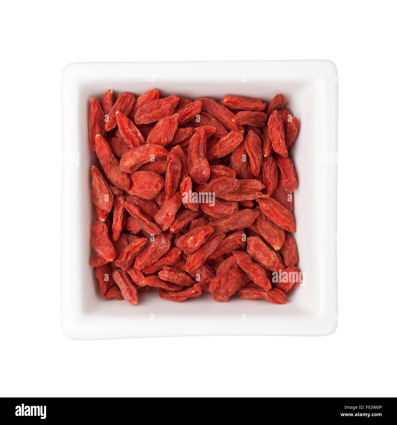 Traditionelle chinesische Medizin - getrocknete Goji-Beeren in eine quadratische Schale isoliert auf weißem Hintergrund Stockfoto