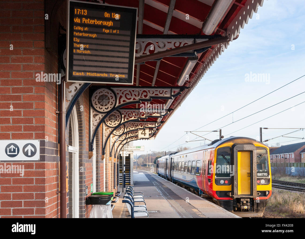 East Midlands Trains Zug auf Gleis 4 und die Anzeigetafel die Abfahrtszeit, Grantham Bahnhof, Grantham, England, Großbritannien Stockfoto