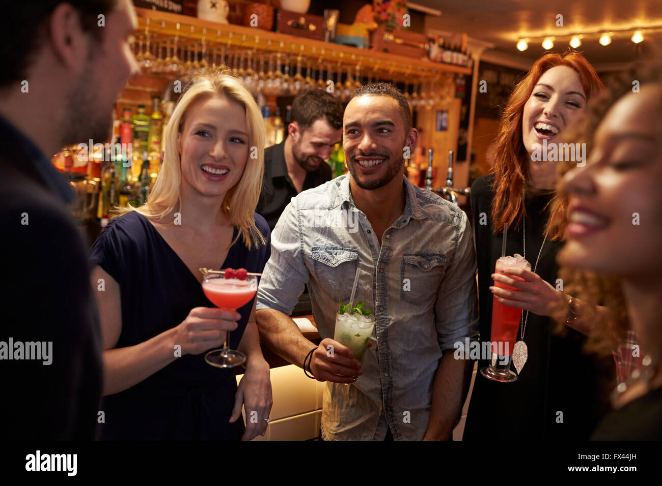 Gruppe von Freunden treffen für Getränke am Abend In der Cocktail-Bar Stockfoto