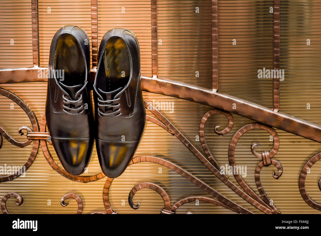 Paar schwarze Schuhe an einem Zaun aufgehängt Stockfoto