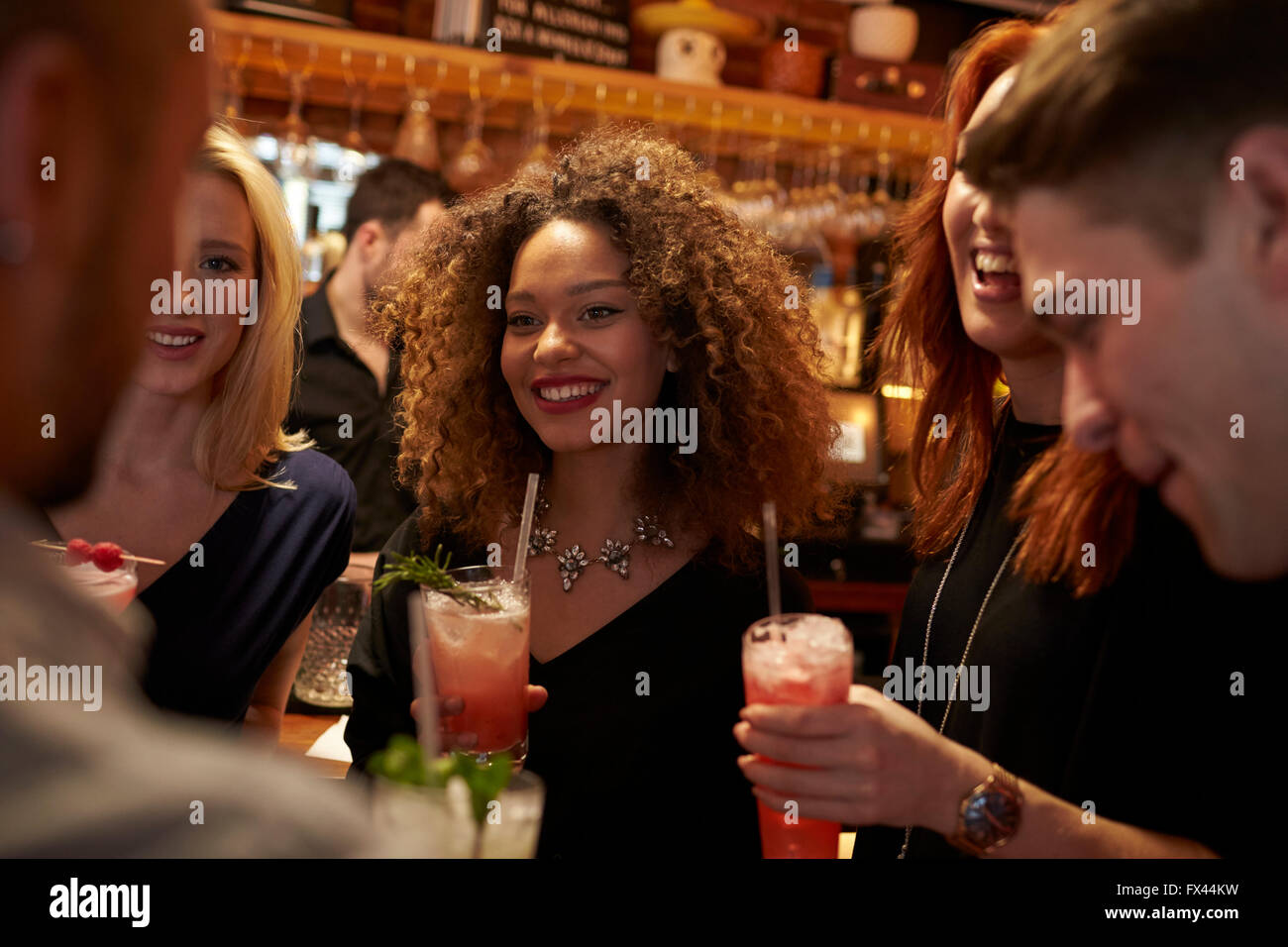 Gruppe von Freunden treffen für Getränke am Abend In der Cocktail-Bar Stockfoto