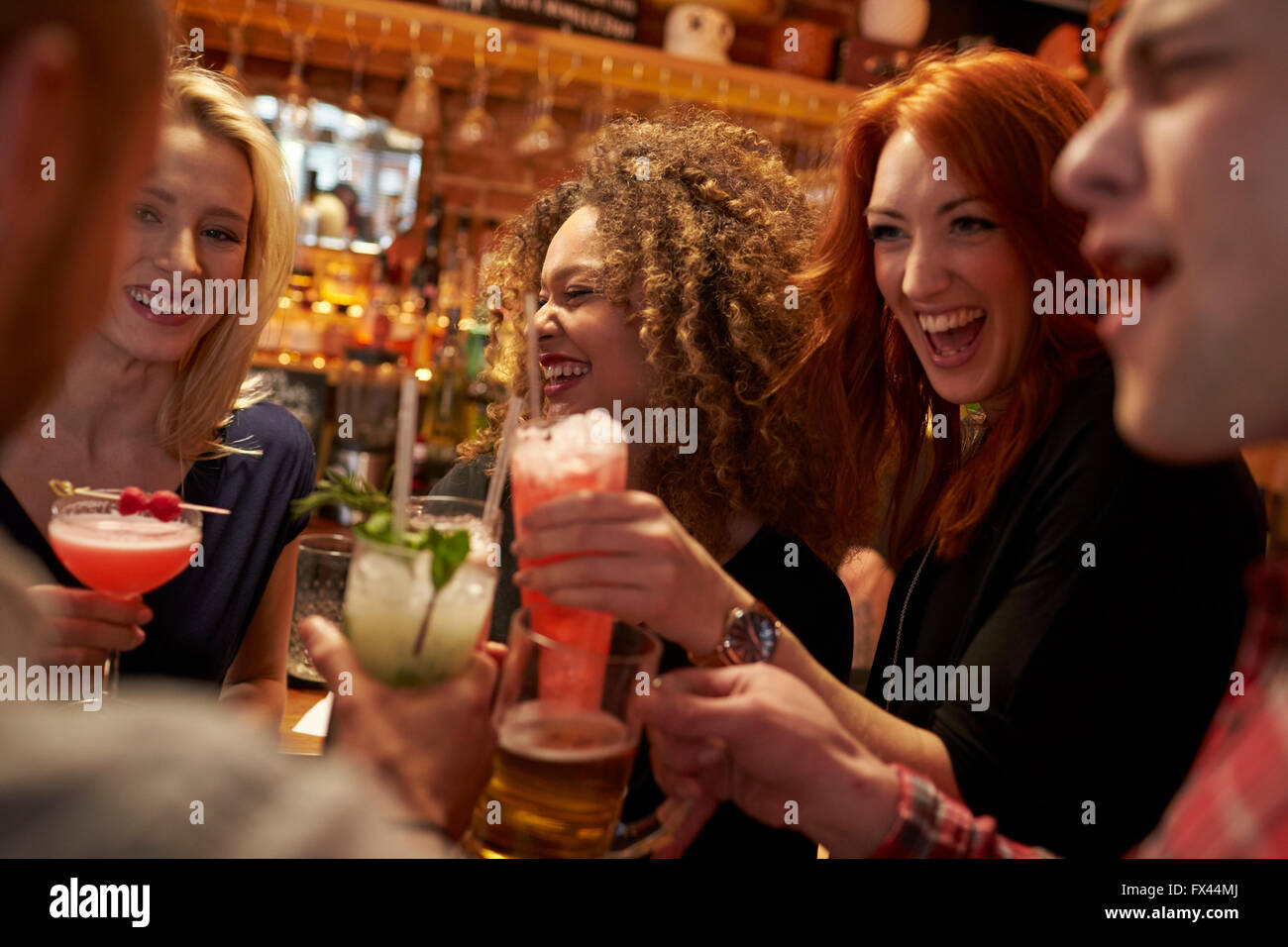 Gruppe von Freunden treffen für Getränke am Abend In der Cocktail-Bar Stockfoto