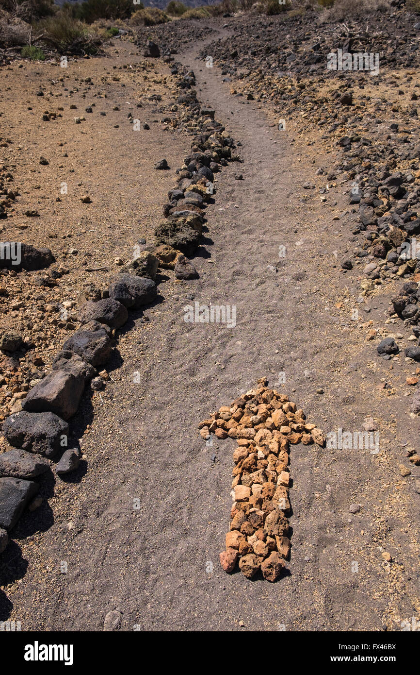 Pfeil auf dem Boden hergestellt aus kleinen Steinen auf eine Wanderroute in der Las Canadas del Teide National Park, Teneriffa, Kanarische Islan Stockfoto