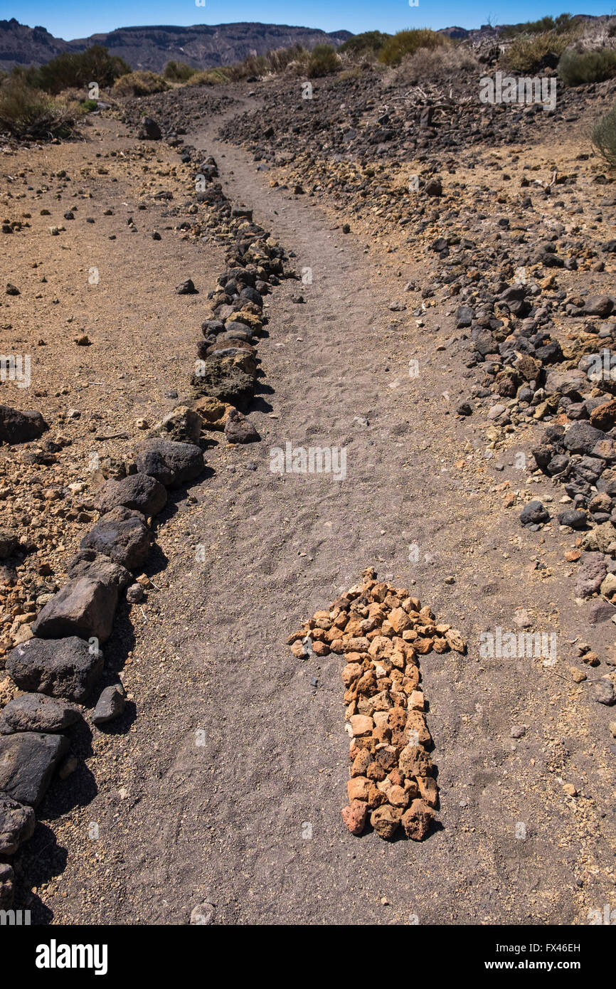 Pfeil auf dem Boden hergestellt aus kleinen Steinen auf eine Wanderroute in der Las Canadas del Teide National Park, Teneriffa, Kanarische Islan Stockfoto