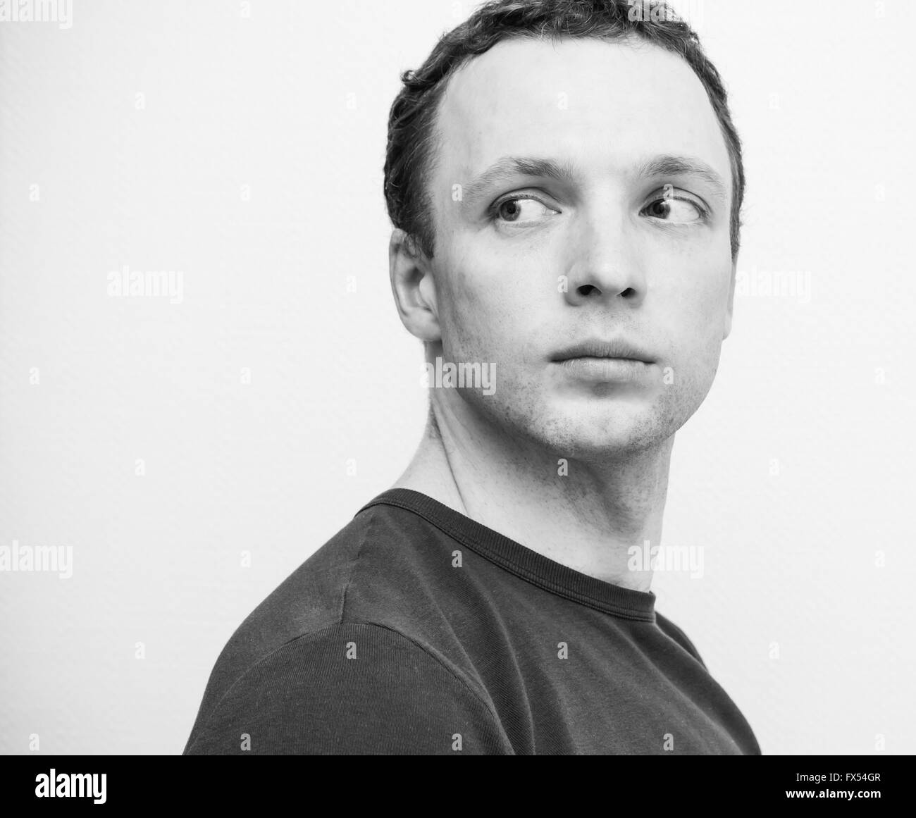 Ernsthafte kaukasischen Jüngling, Closeup Studioportrait über weiße Wand Hintergrund, schwarz / weiß Foto Stockfoto