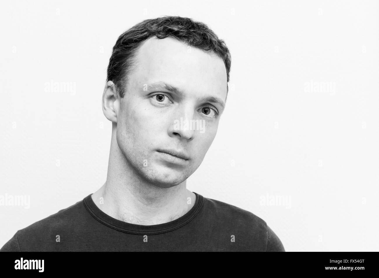 Ernsthafte kaukasischen Jüngling, close-up Studioportrait über weiße Wand Hintergrund, schwarz / weiß Foto Stockfoto