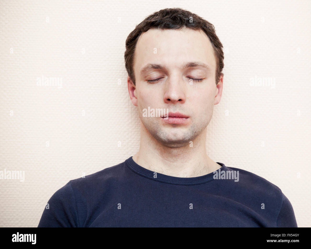 Kaukasischen Jüngling mit geschlossen Augen. Studio-Porträt über graue Wand Hintergrund Stockfoto