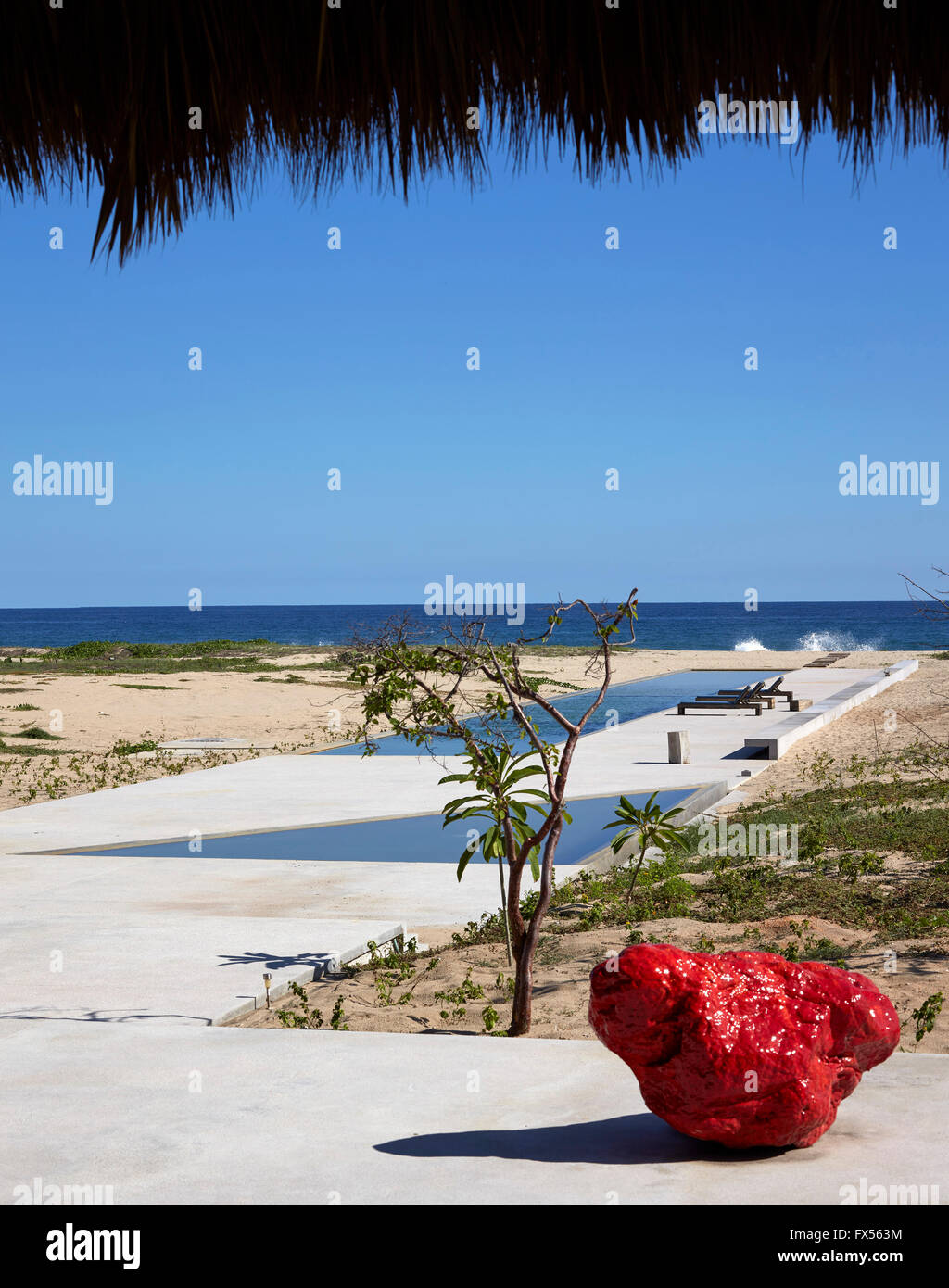 Blick von innen Palapa in Richtung Pool und Meer mit Bosco Sodi Skulptur im Vordergrund. Casa Wabi, Puerto Escondido, Mexiko. Archi Stockfoto