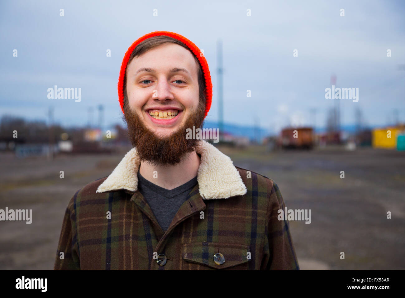 Modern, trendy, Hipster Kerl in einem verlassenen Güterbahnhof in der Abenddämmerung im Portrait Mode Stil. Stockfoto