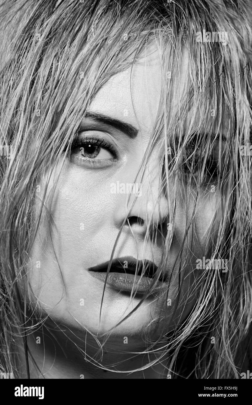 Porträt von einem schönen Mädchen in schwarz und weiß mit Haaren bedeckte ihr Gesicht Stockfoto