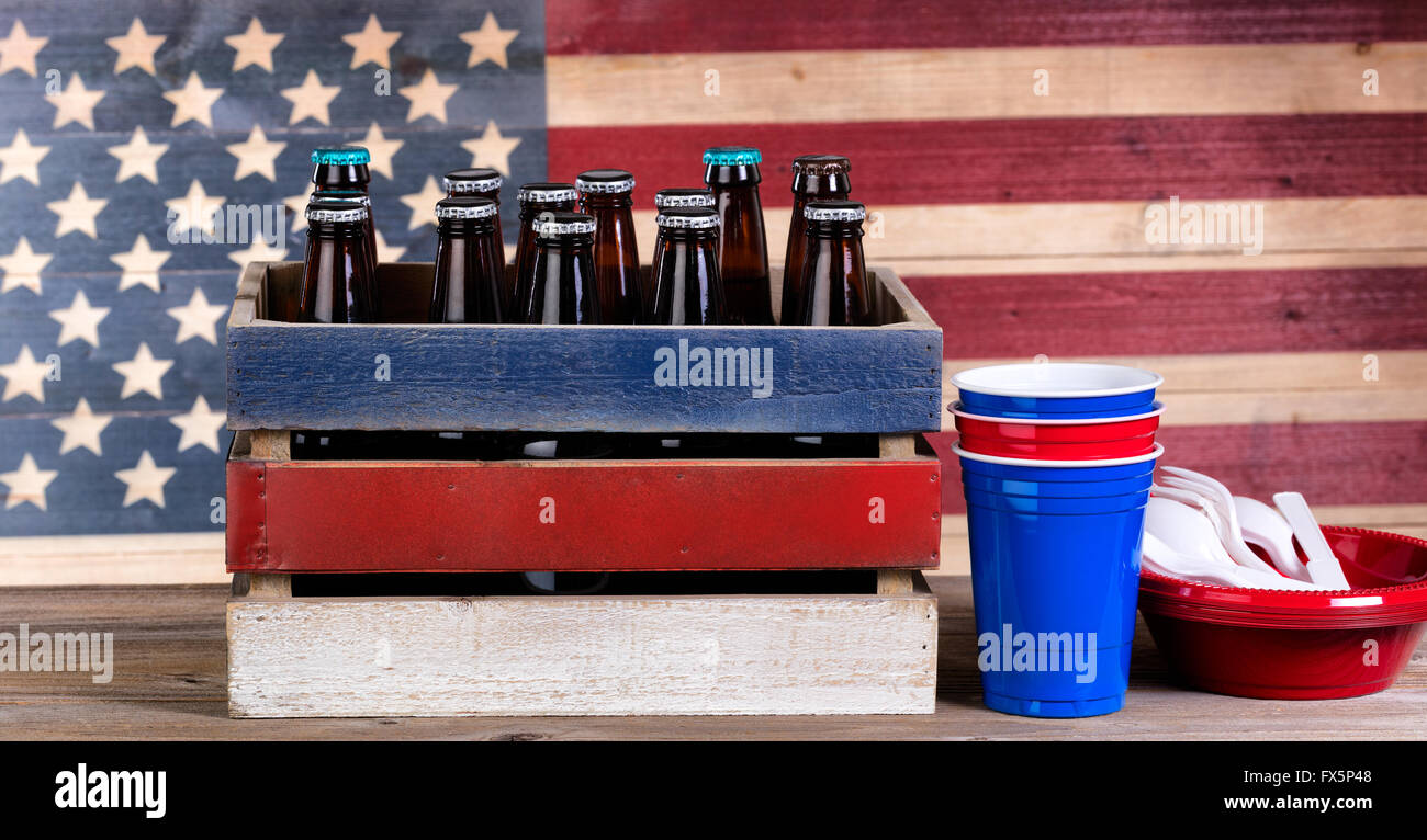 Kiste Bier und Party Sachen für Fourth Of July-fest mit Vintage Holz USA-Flagge im Hintergrund. Stockfoto