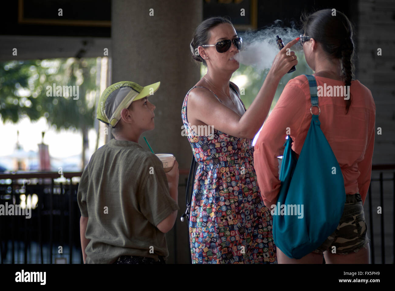 Passives Rauchen. Mutter e Zigarette rauchen und blasen Rauch in das Gesicht des Kindes. Stockfoto