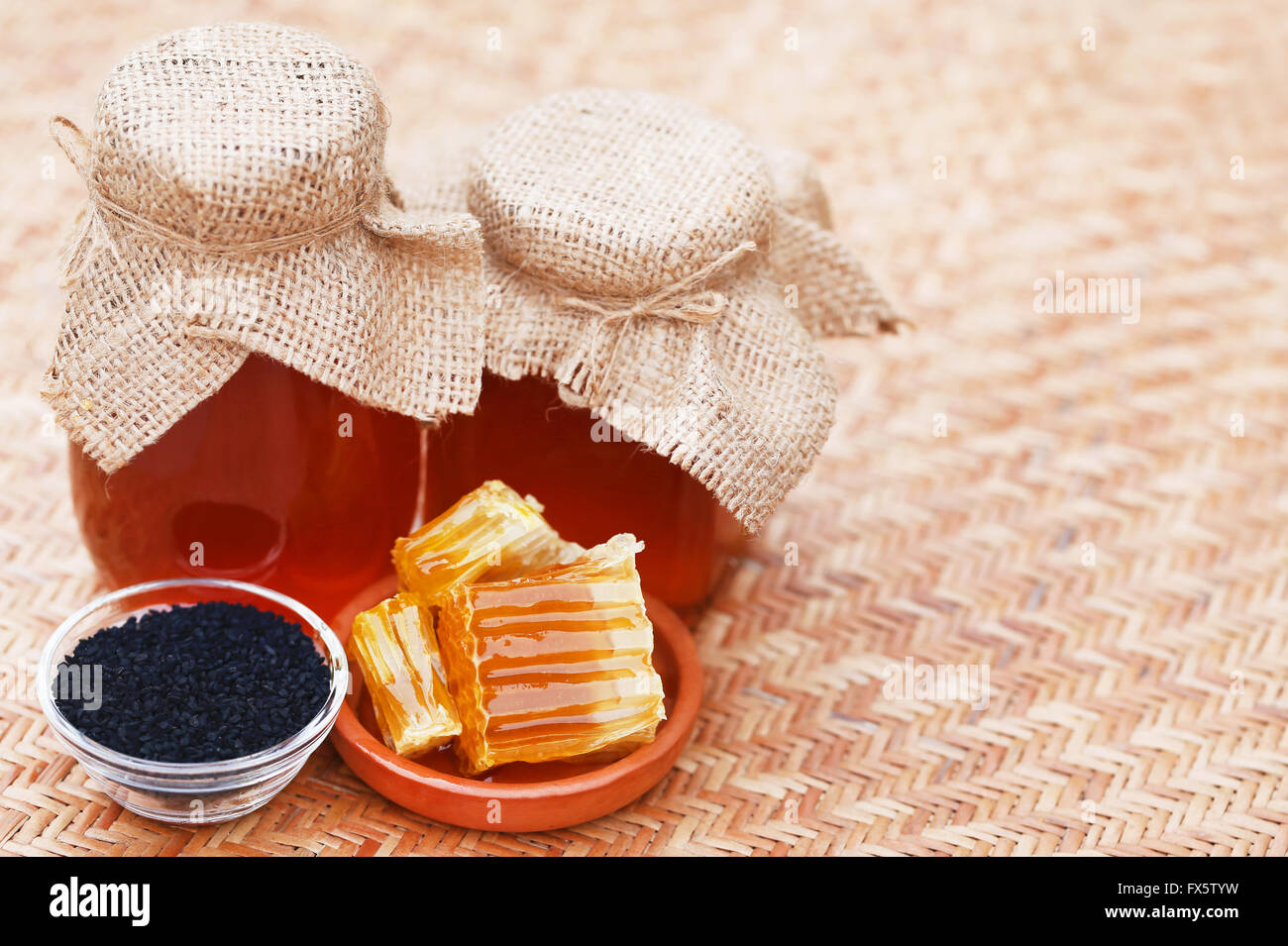 Honig mit Schwarzkümmel auf strukturierte Oberfläche Stockfoto