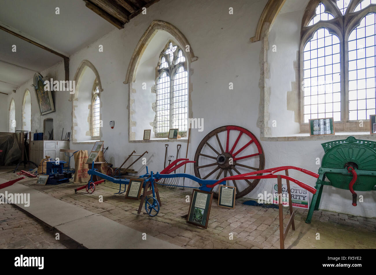 Verschiedene antike landwirtschaftliche Geräte auf dem Display in einer Kirche Stockfoto