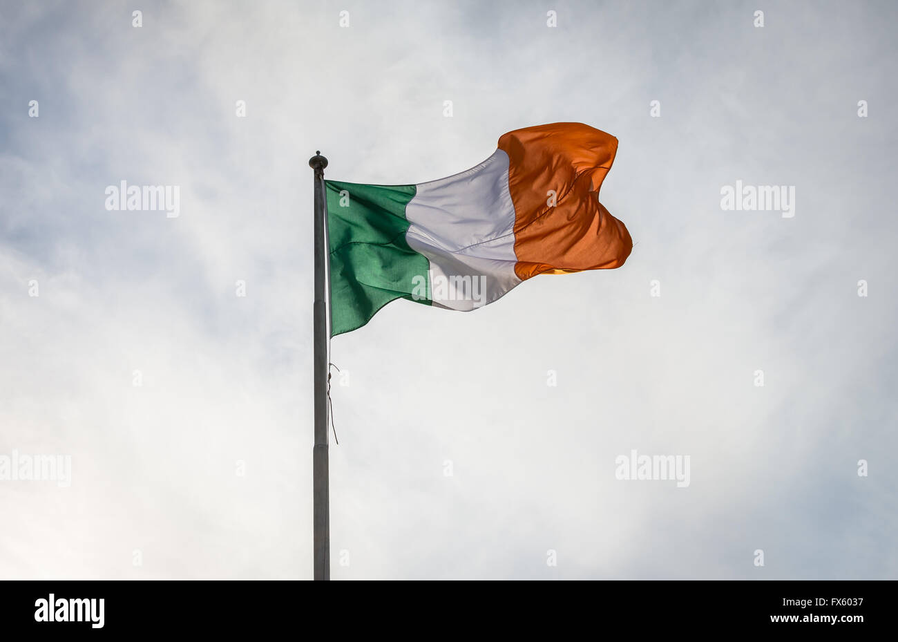 Die irische Trikolore fliegt von Fahnenstange. Die Nationalflagge von Irland. Stockfoto