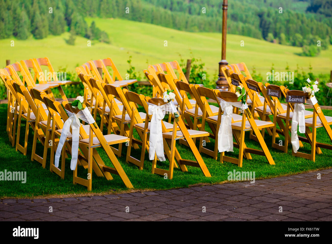 Lehrstühle an diesem Ort für Hochzeiten sind aus Holz und sehen aus wie schöne elegante Sitzgelegenheiten für die Gäste. Stockfoto