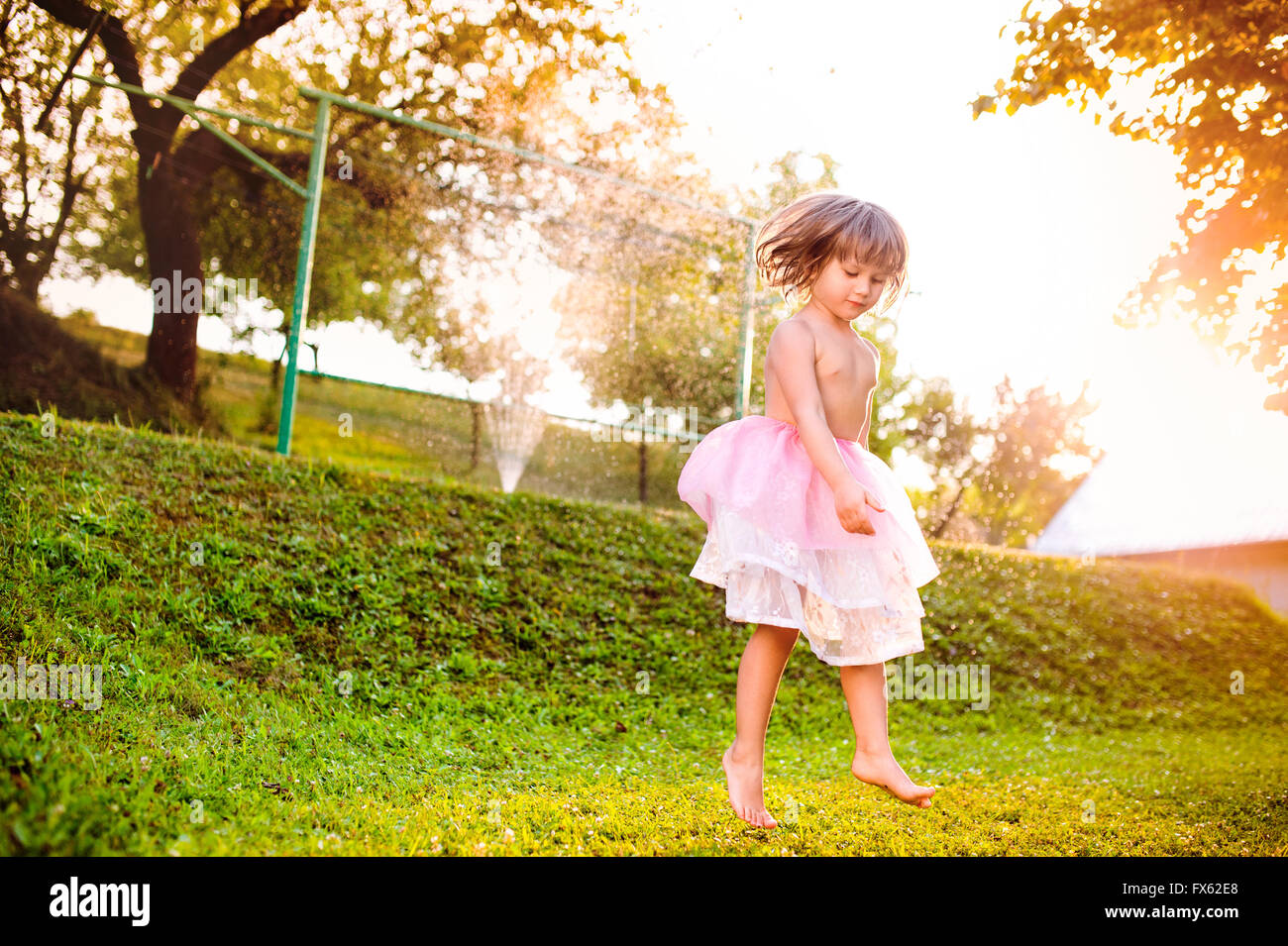 Mädchen in Prinzessin Rock im sonnigen Garten springen Stockfoto