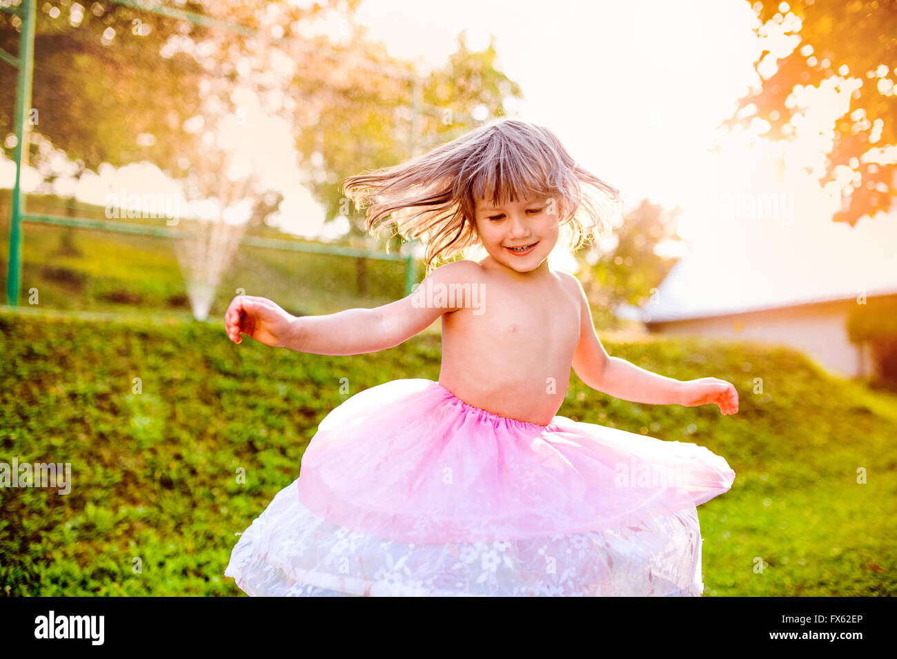 Mädchen in Prinzessin Rock Spinnen in sonniger Sommergarten Stockfoto