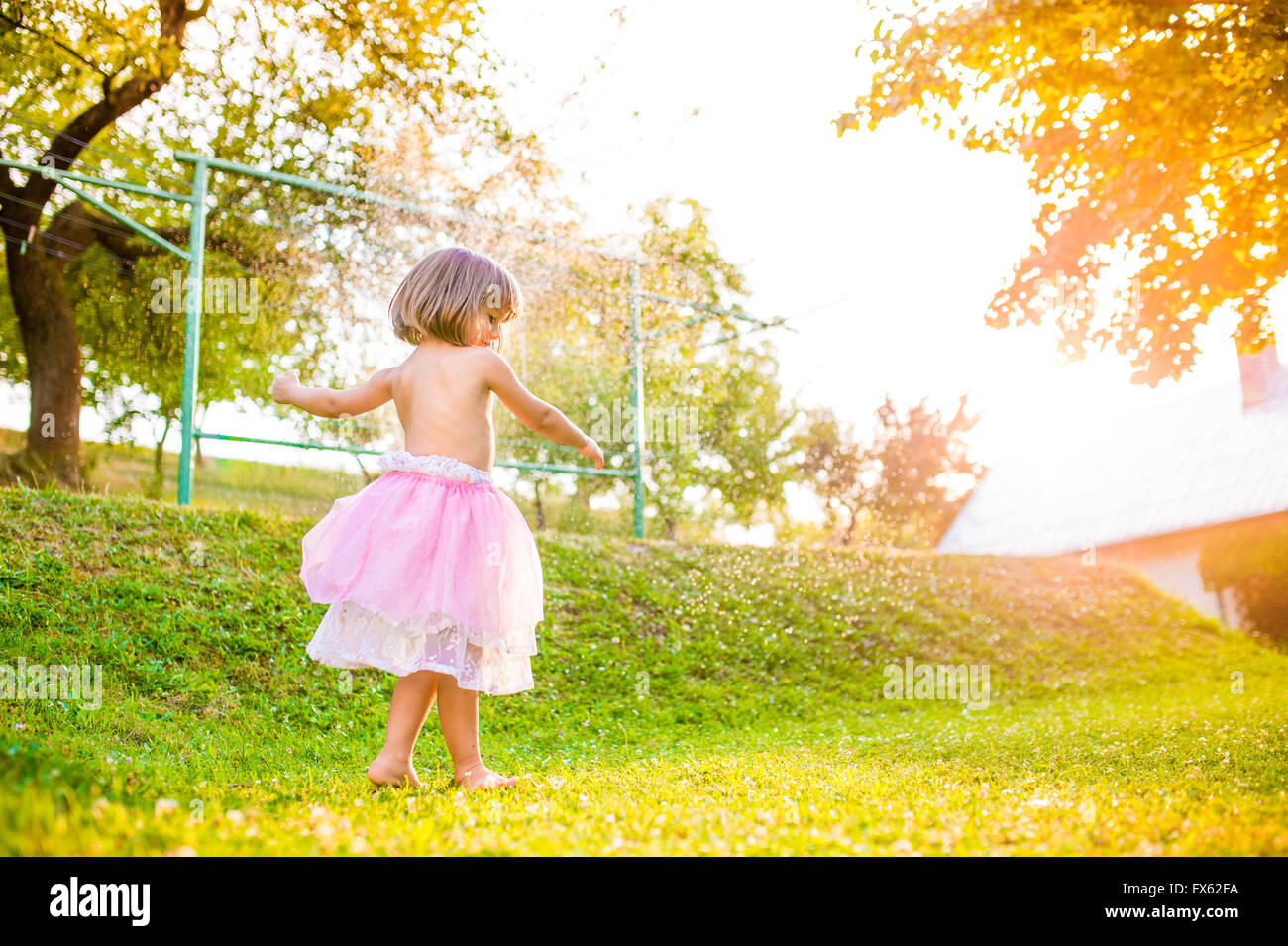 Mädchen in Prinzessin Rock läuft in sonniger Sommergarten Stockfoto
