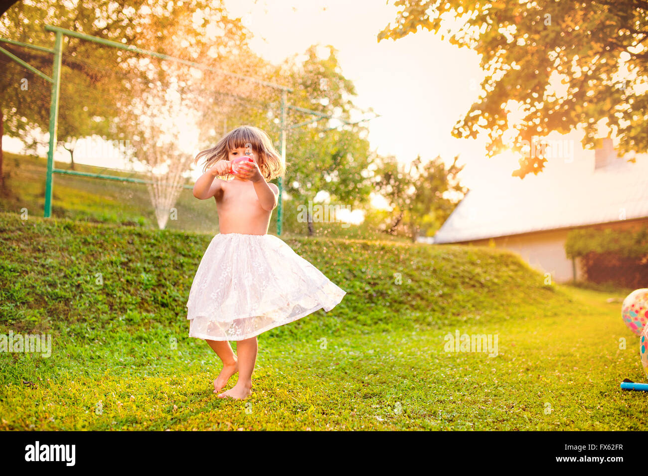 Mädchen in Prinzessin Rock tanzen in sonniger Sommergarten Stockfoto