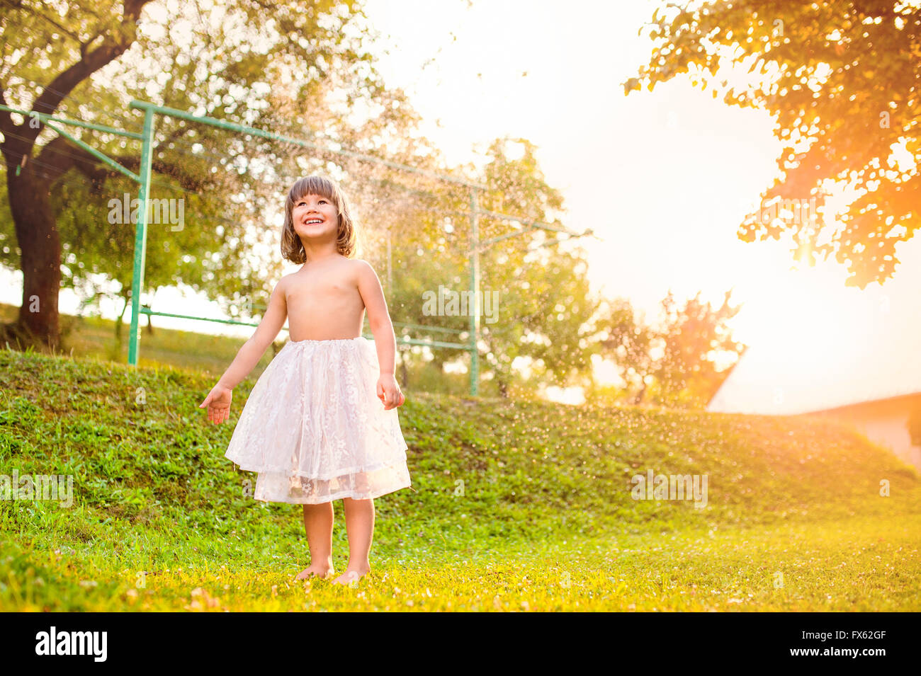 Mädchen in Prinzessin Rock steht in sonniger Sommergarten Stockfoto