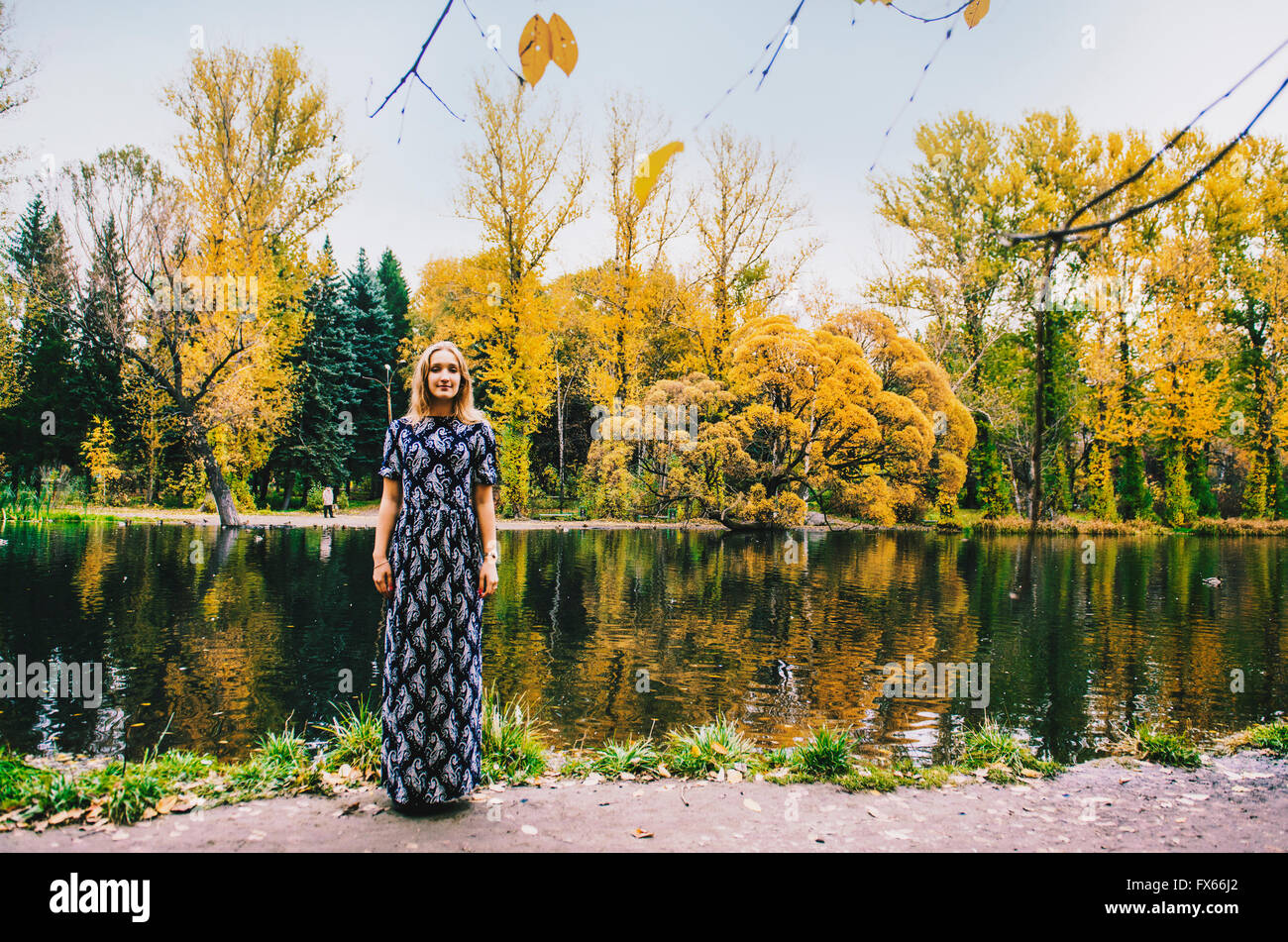 Kaukasische Frau lächelnd in der Nähe von Teich im park Stockfoto