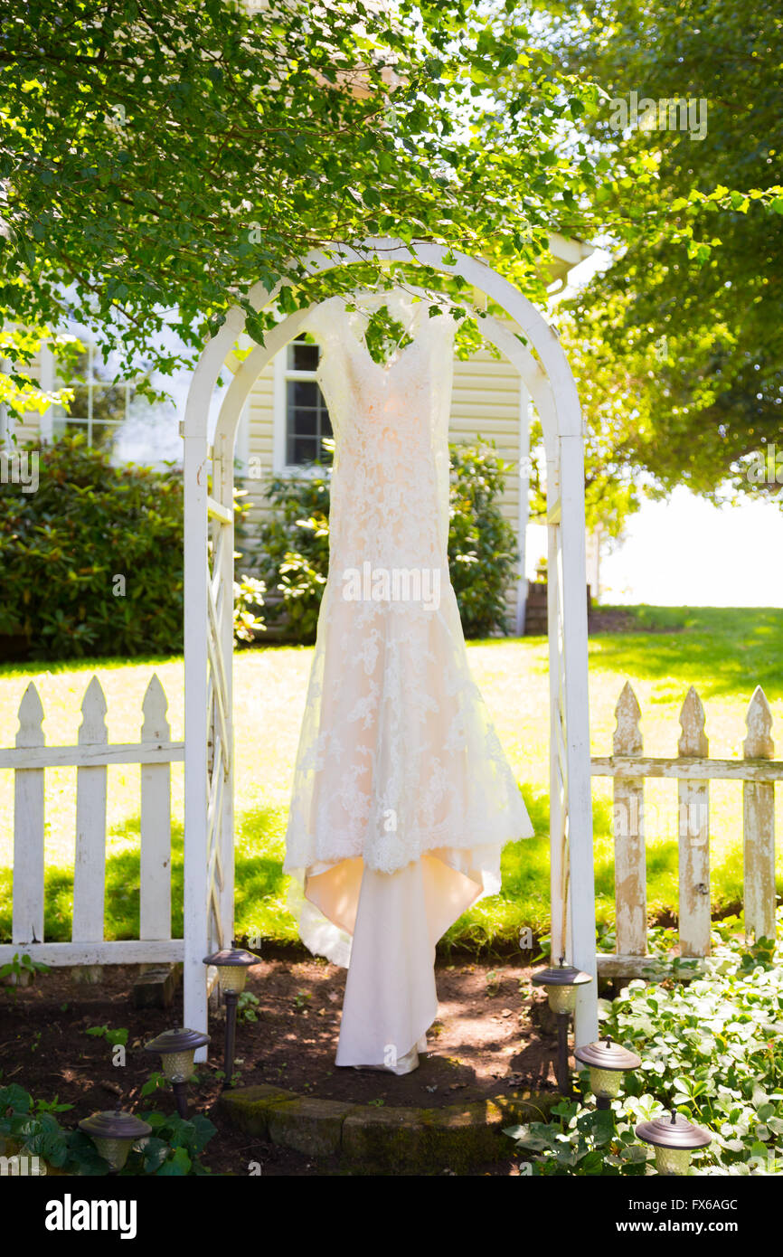 Weiße Designer Brautkleid hängen in einem Garten im Freien in Oregon. Stockfoto