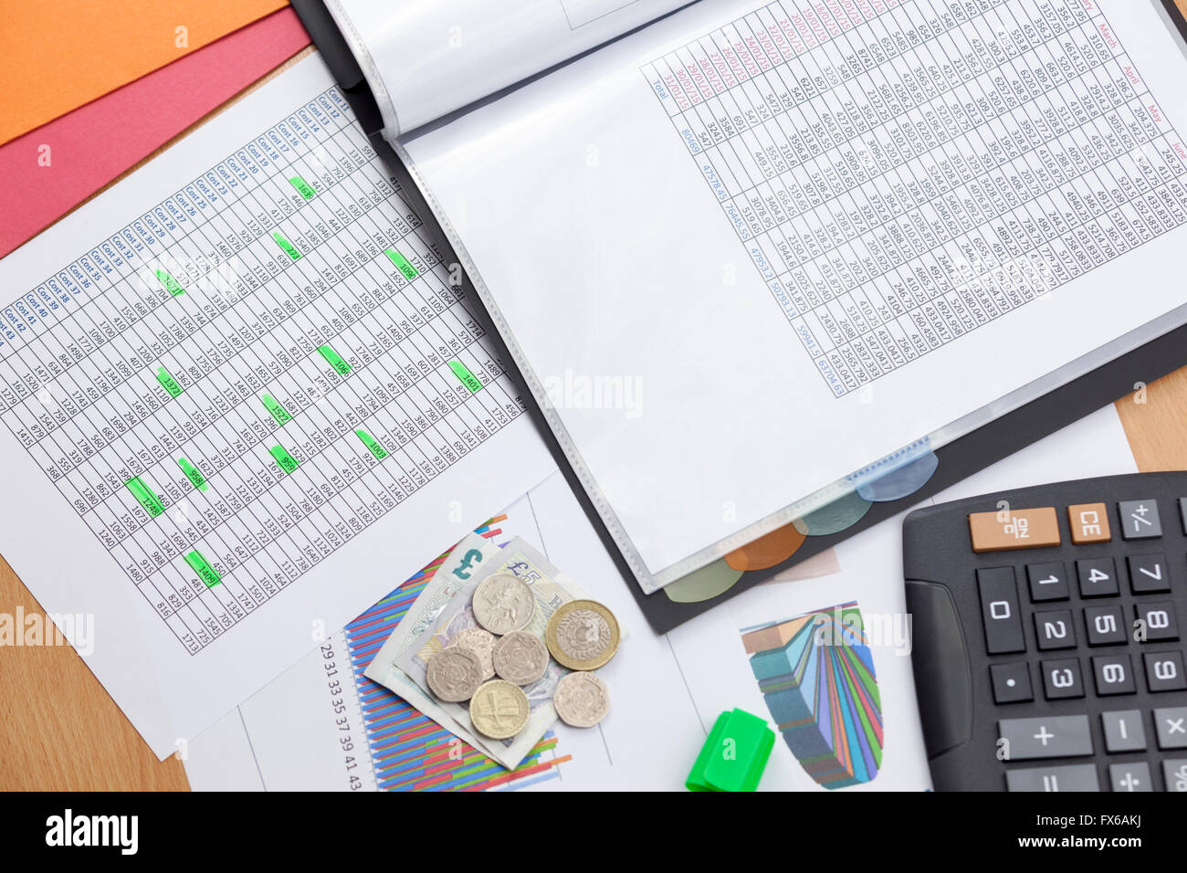 Finanziers desktop zeigt zwei Berichte über die Verkäufe mit einem Taschenrechner und Bargeld lose Verlegung auf einem Diagramm Ausdruck beschäftigt Stockfoto