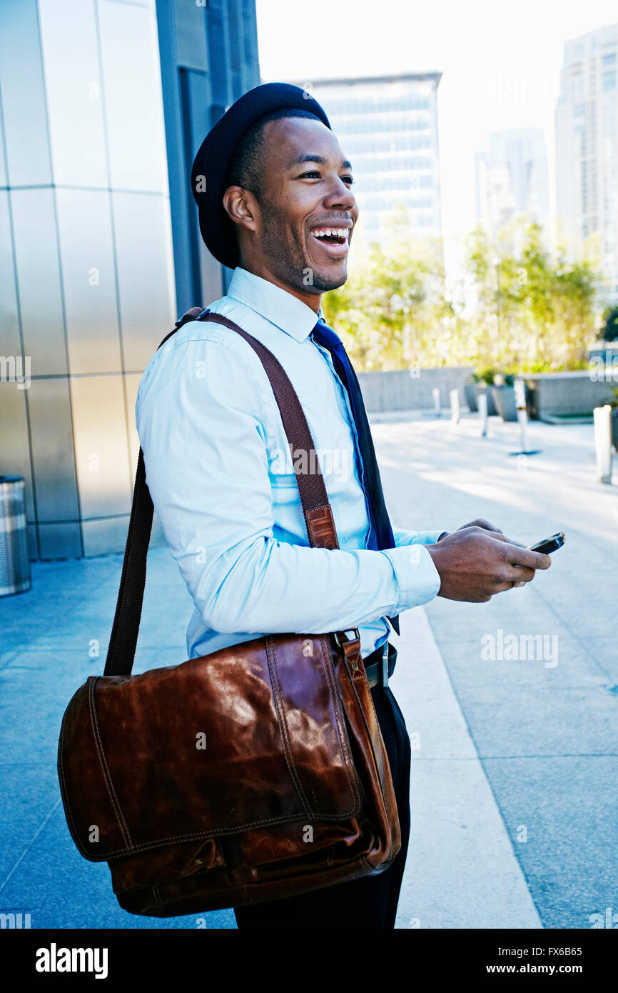 Schwarze Geschäftsmann mit Handy vor Bürogebäude Stockfoto