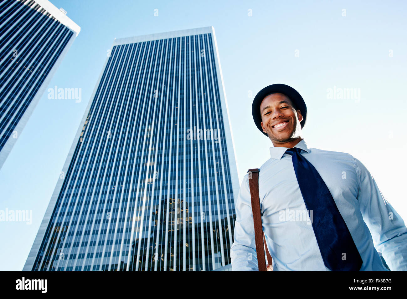 Schwarze Geschäftsmann lächelnd unter Hochhäuser Stockfoto