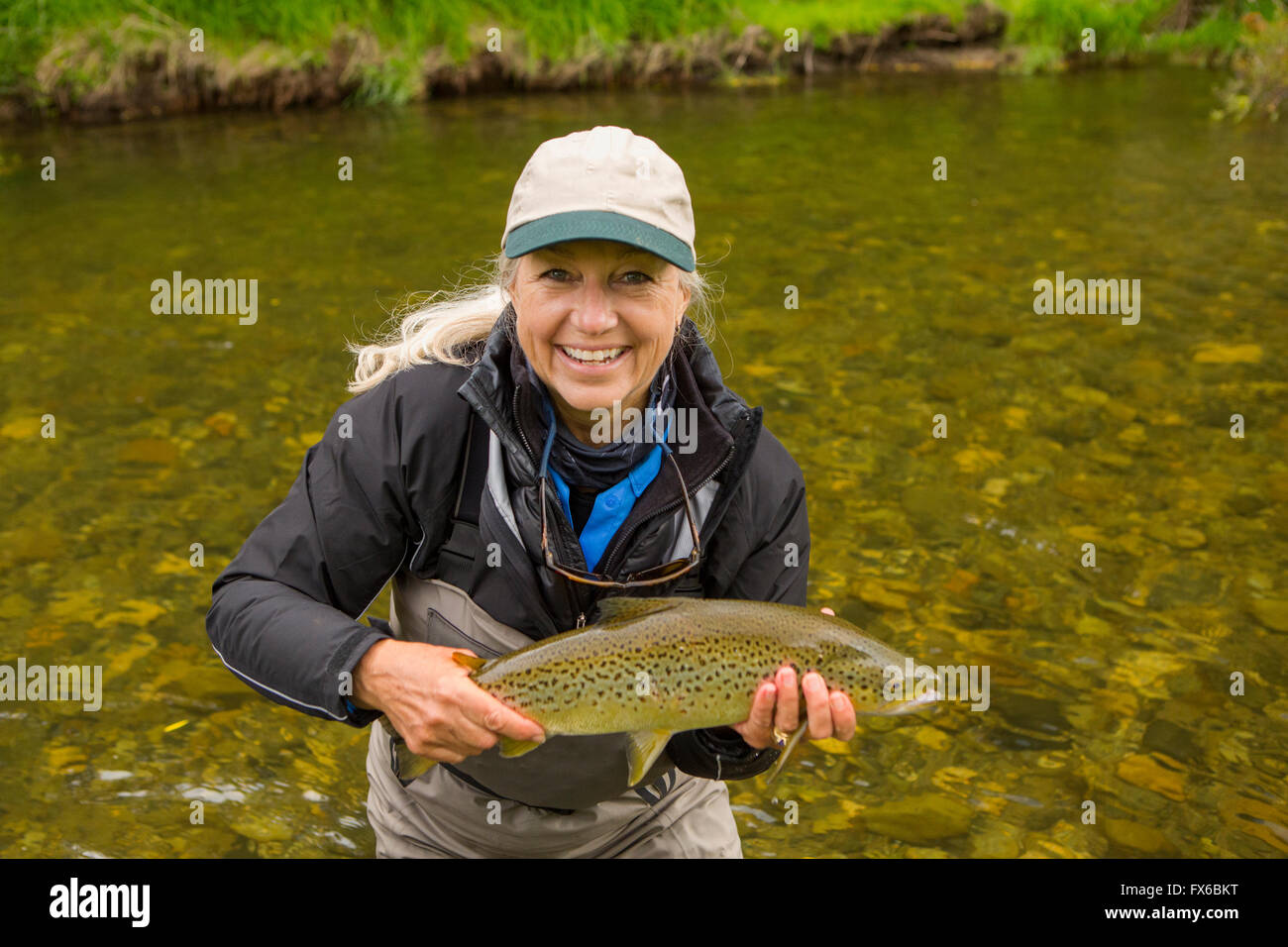 Kaukasische Frau mit Fisch in abgelegenen Fluss Stockfoto