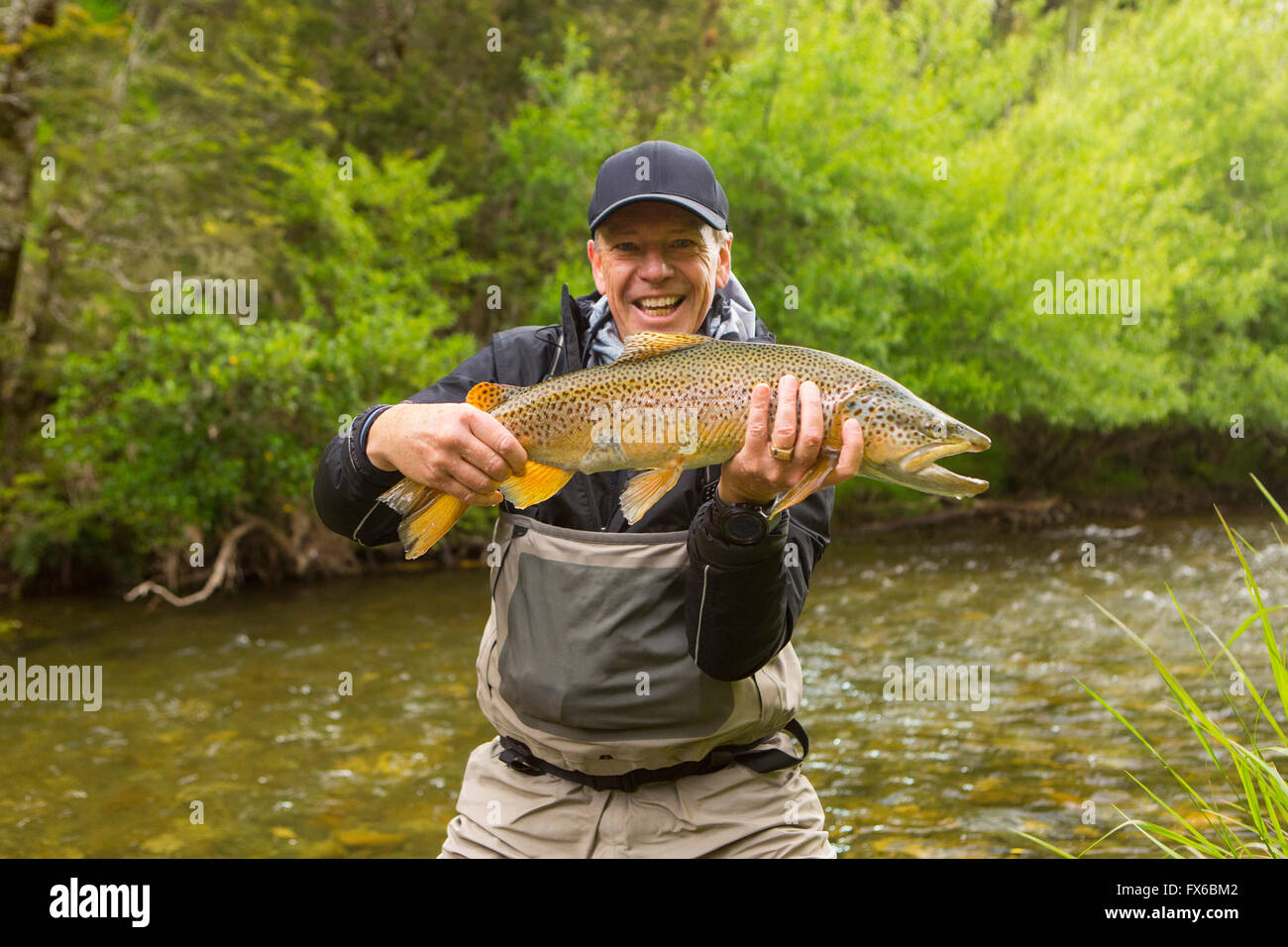 Kaukasischen Mann mit Fisch in abgelegenen Fluss Stockfoto