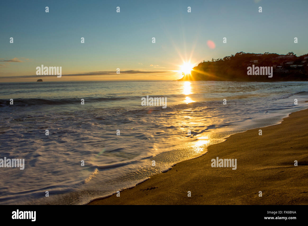 Sonnenuntergang über dem Horizont am einsamen Strand Stockfoto