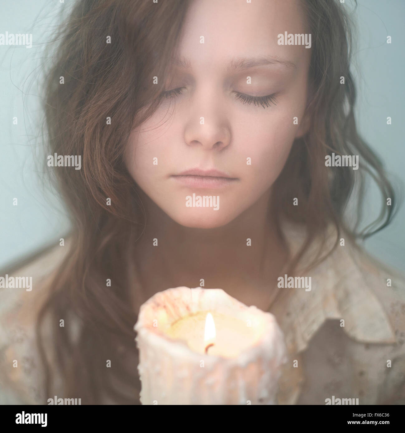 Kaukasische Frau Holding schmelzende Kerze Stockfoto