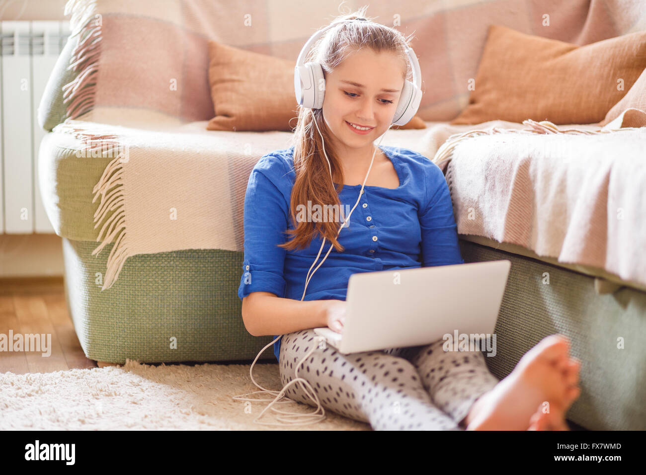 Kaukasische Teenager Mädchen Spass haben, Musik hören oder Videos auf ihrem Laptop zu Hause Stockfoto