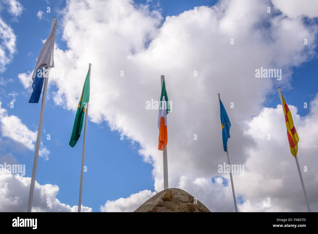 Die irische Trikolore und 4 Flaggen der einzelnen Provinzen fliegt von Milltown Irish Republican Denkmal Grabstelle in Belfast Stockfoto