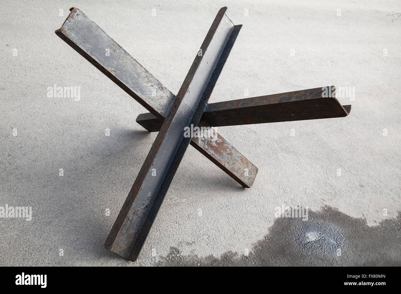 Schwarzer Stahl Straße Barriere in Form von Anti-Tank Tschechische Igel Hindernis Verteidigung steht auf Asphalt urban Straße Stockfoto